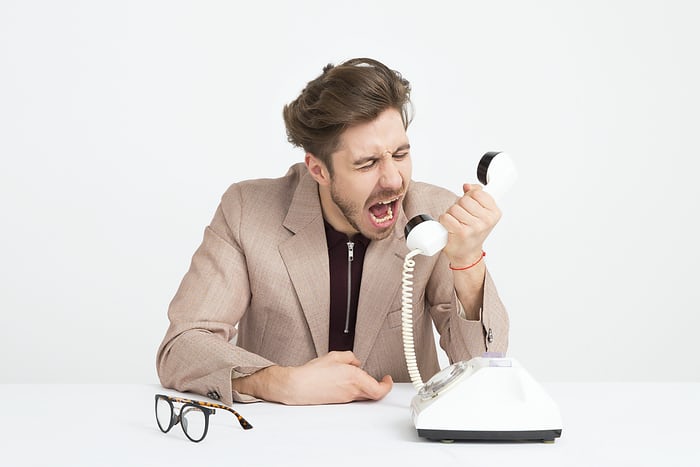 Frustrated remote employee taking out anger on phone