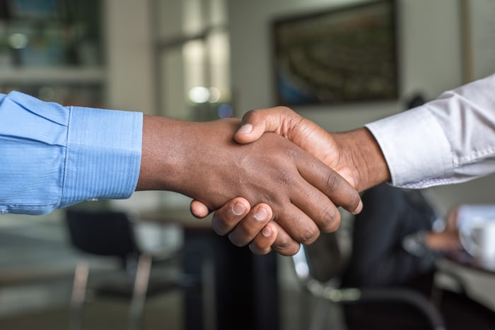 Indian employee shaking hand with happy customer